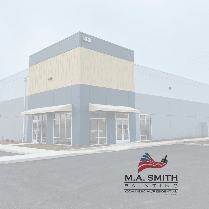 Modern grey and tan commercial building with large windows and M.A. Smith Painting logo.